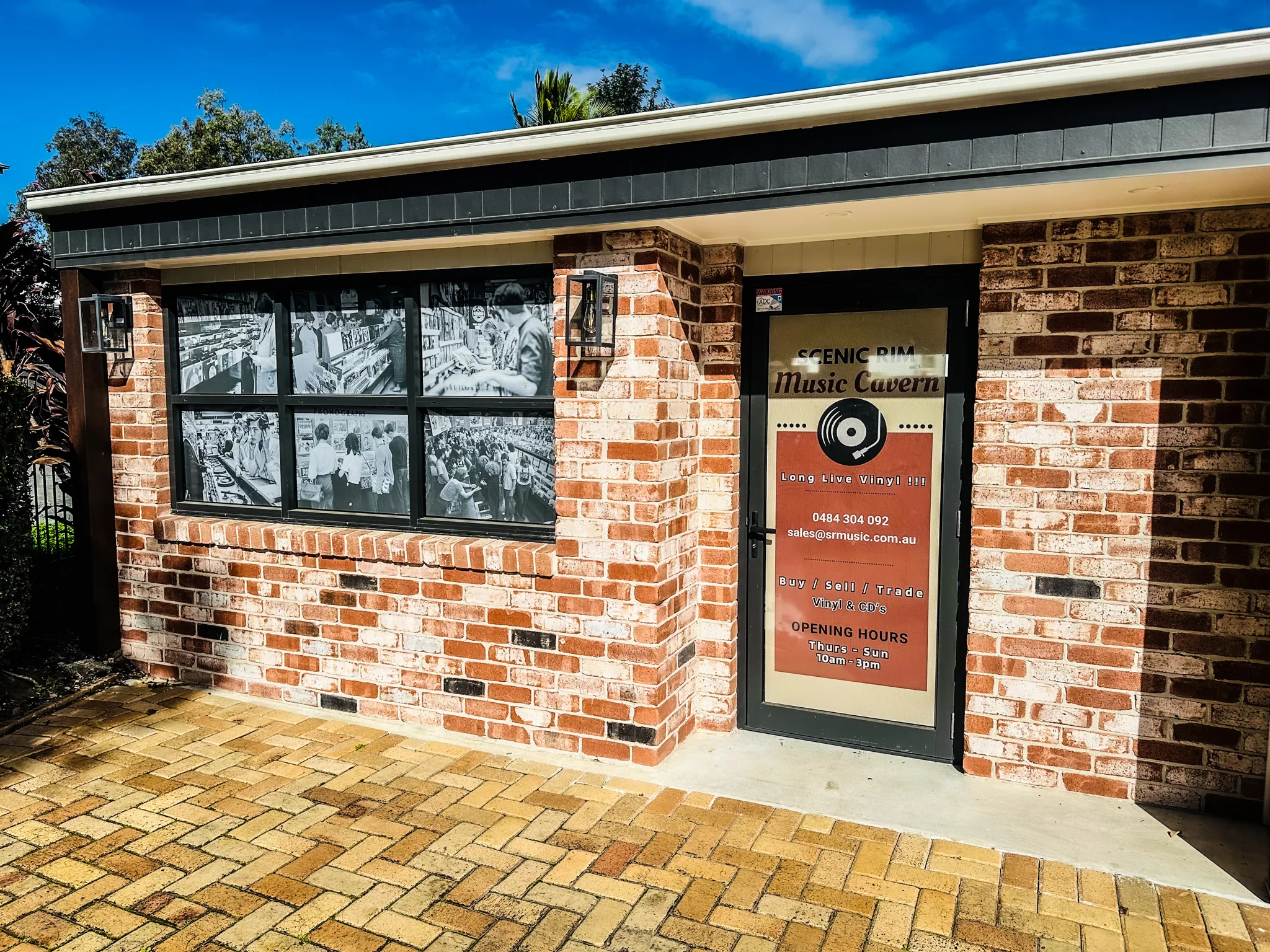The red-brick shopfront of Scenic Rim Music Cavern on Christie Street, Canungra, with record-filled windows